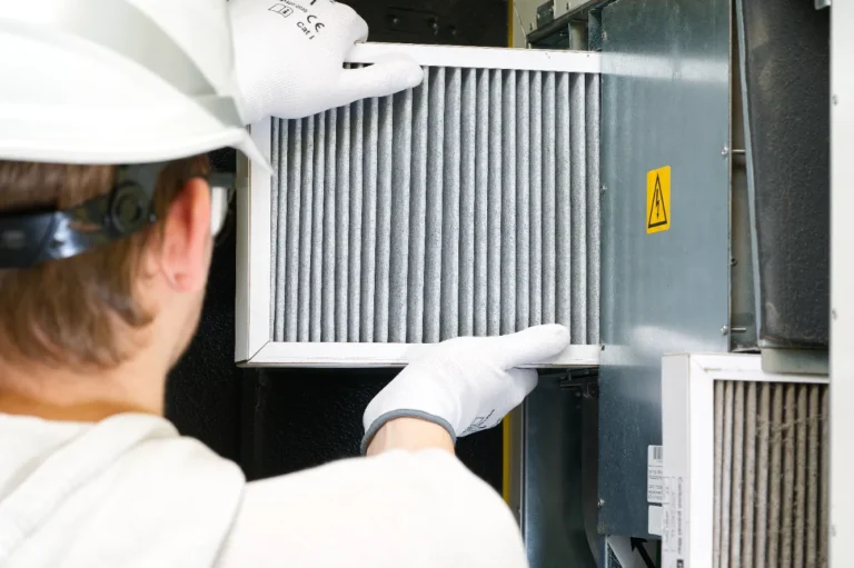 Technician replacing HVAC filter to improve air quality.