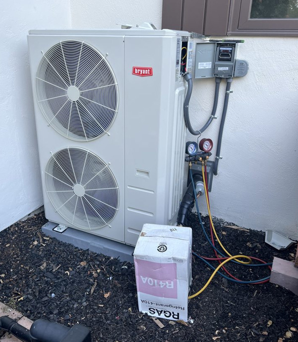 Bryant dual-fan outdoor heat pump connected to refrigerant lines, electrical conduit, and service gauges in San Jose, CA.
