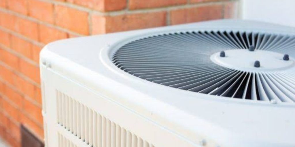 HVAC technician inspecting an air conditioning system affected by changing weather conditions to maintain efficient heating and cooling | How Weather Impacts HVAC Systems