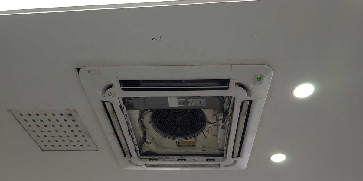 A ceiling-mounted HVAC cassette air conditioner unit showing potential leak risk areas that can threaten home structure safety.