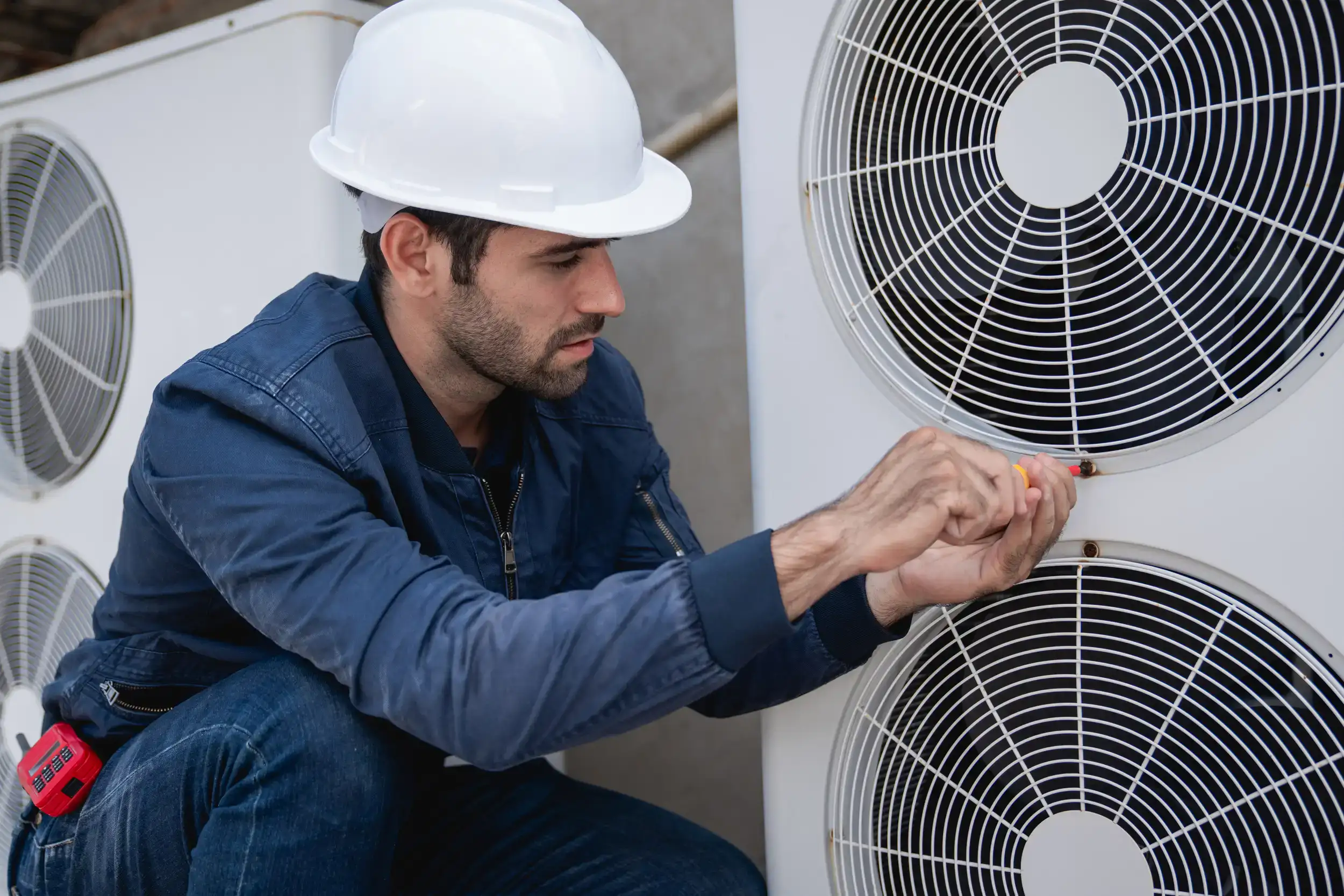 Service worker checking the cooling system of the HVAC equipment.